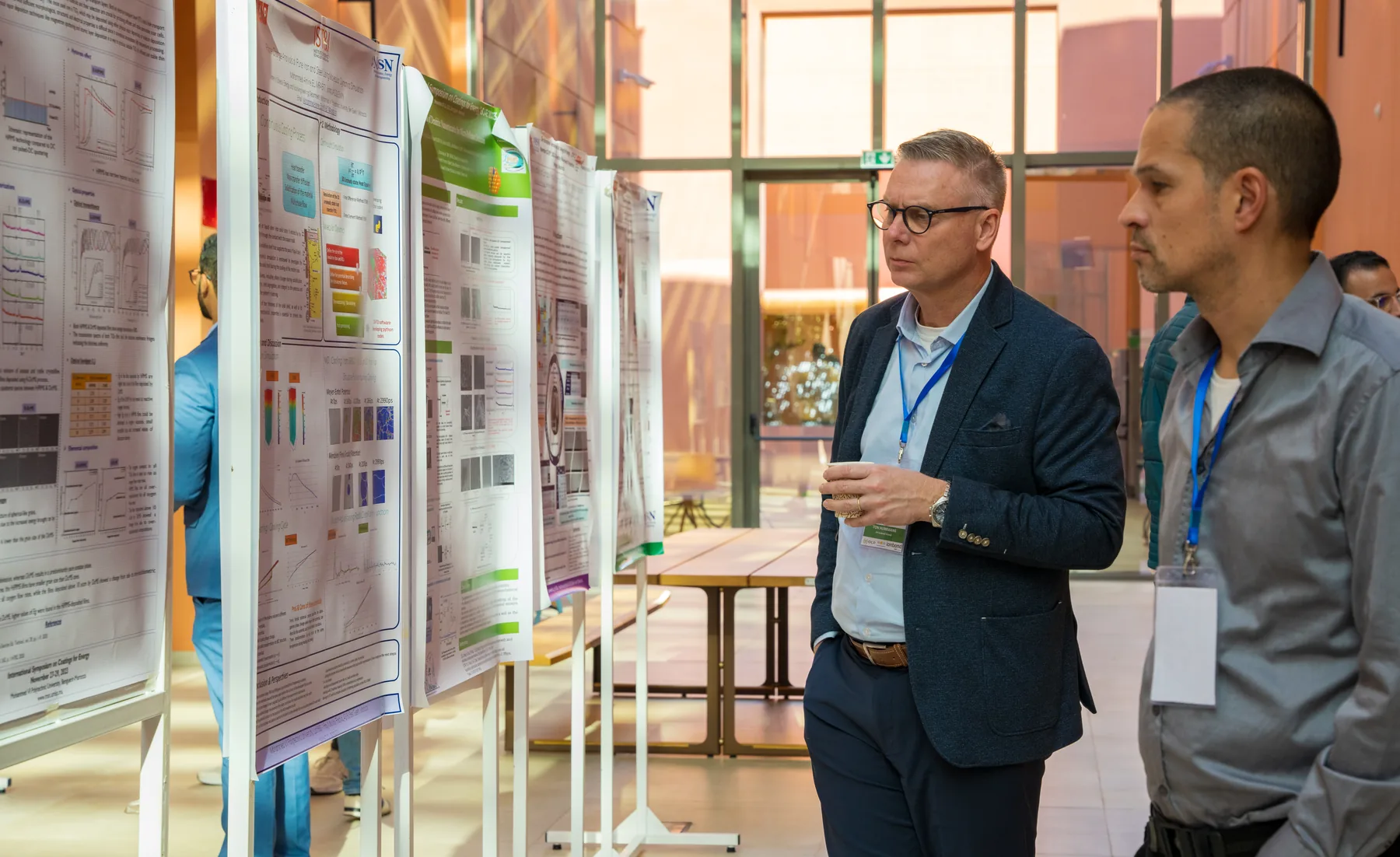 Researchers exchanging ideas beside posters